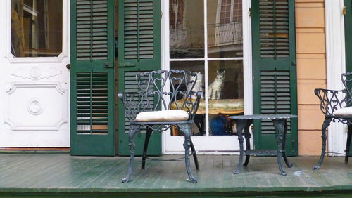 Empty chairs and tables against building