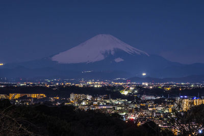 Aerial view of illuminated cityscape against sky at night