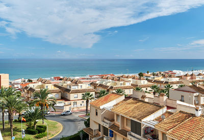 High angle view of buildings by sea against sky