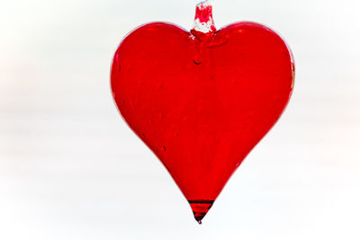 Close-up of red heart shape on white surface