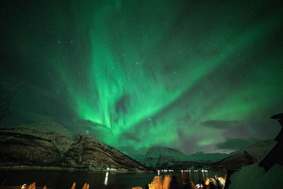 Aerial view of illuminated mountain against sky at night during winter