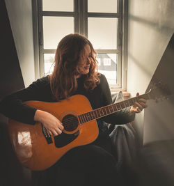 Man playing guitar at home