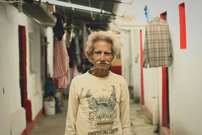 Portrait of senior man standing in alley