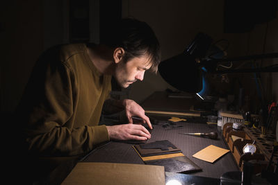 Side view of man working at table