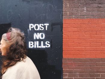 CLOSE-UP OF WOMAN STANDING ON WALL