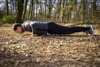 Man with the blue eyes and mustache is doing push-ups on the floor while listening to the music.