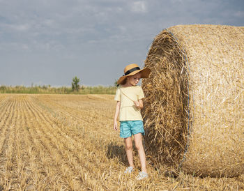 Little girl having fun in a wheat field on a summer day. 