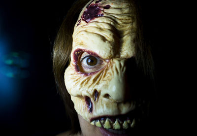 Close-up portrait of woman wearing spooky mask