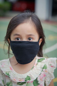 Close-up portrait of girl wearing mask