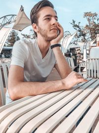 Portrait of young man sitting on table