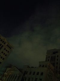 Buildings in city against cloudy sky