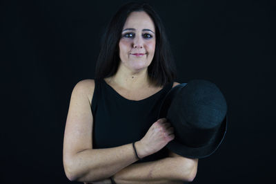 Portrait of a smiling young woman against black background