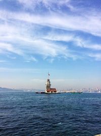 Lighthouse by sea against sky