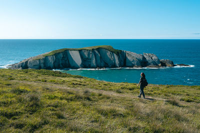 Asian girl hiking along the coast in spring during the sunset