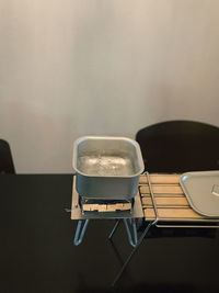 Close-up of empty seats on table against wall