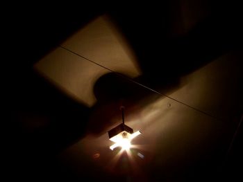 Low angle view of illuminated pendant light hanging from ceiling