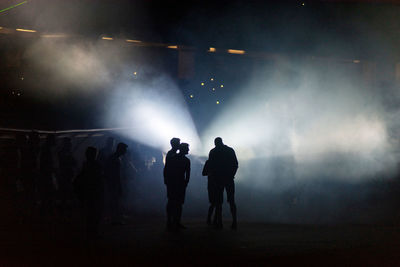 Silhouette people in illuminated stadium