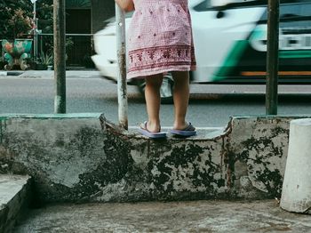 Low section of little girl standing in city