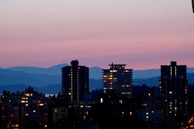 Illuminated buildings against sky during sunset