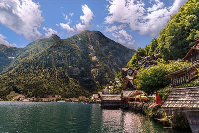 Scenic view of river by mountains against sky