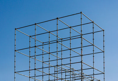 Low angle view of crane against clear blue sky