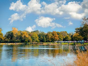 Scenic view of lake by trees against sky