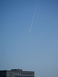 Low angle view of vapor trail against clear blue sky