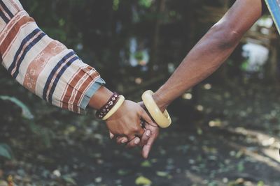 Cropped image of female friends holding hands