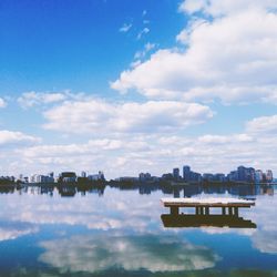 Scenic view of lake against sky in city