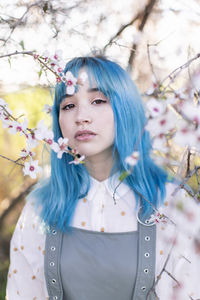 Portrait of beautiful woman standing by flowering plants