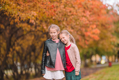 Happy girl standing on autumn leaves