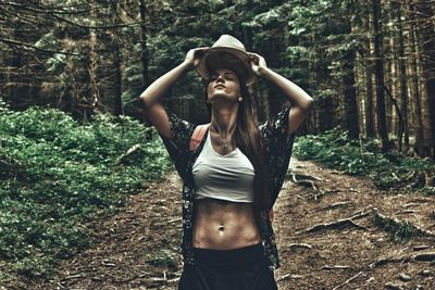 Portrait of young woman standing in forest