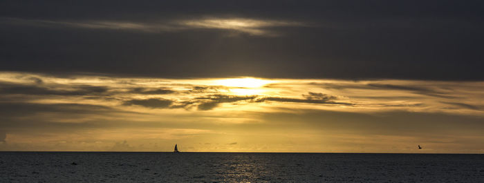 Scenic view of dramatic sky over sea during sunset
