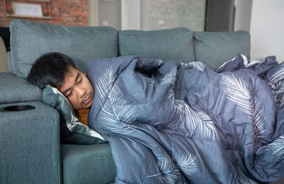 Man sleeping on sofa at home