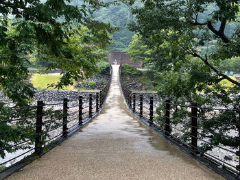 Rear view of man walking on footbridge