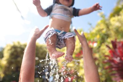 Low angle view of shirtless boy against sky