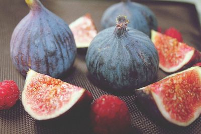 Close-up of figs and raspberries on tablecloth