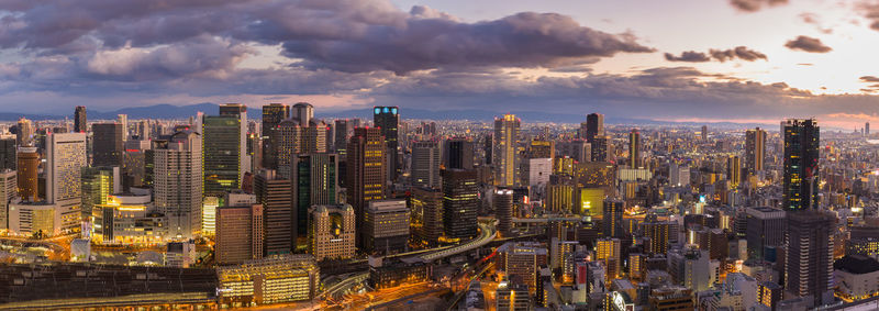 Aerial view of cityscape against cloudy sky