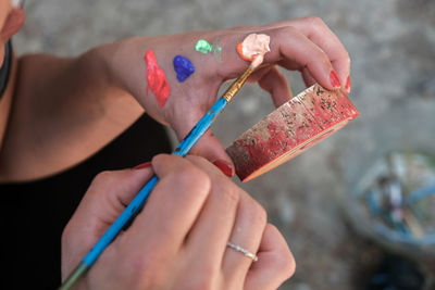 Cropped hand of woman holding equipment