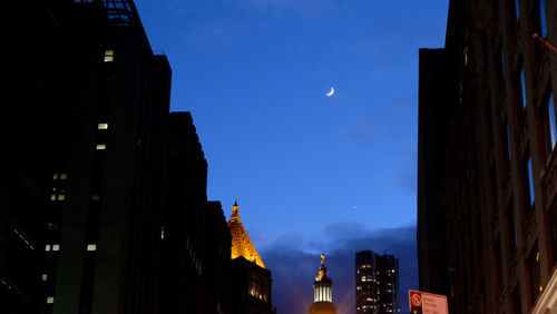 Low angle view of illuminated city against sky at night