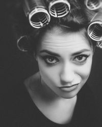 Close-up portrait of smiling young woman with curlers