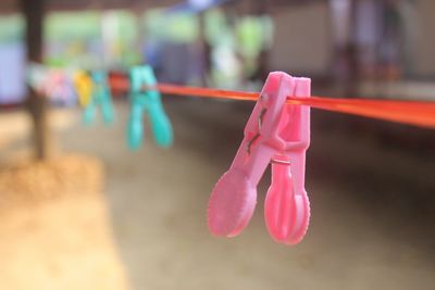 Close-up of pink clothespins hanging on clothesline