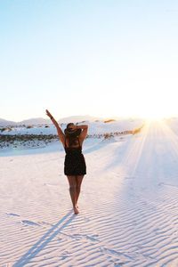 Woman standing on beach against clear sky