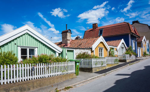 Residential buildings by road against sky