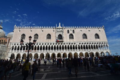 People at doges palace against sky