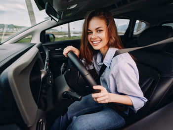 Portrait of young woman sitting in car