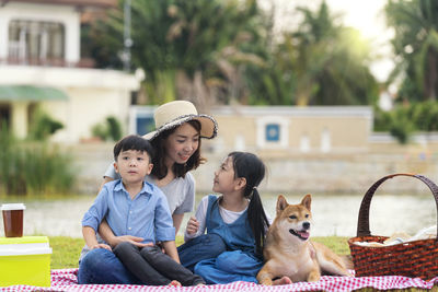 A family with a father, mother and daughter, son on a picnic and play with shiba inu puppies