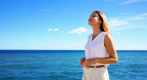 Portrait of young woman relaxing breathing fresh air on sea