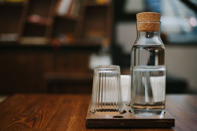 Water in glass by bottle on table in restaurant