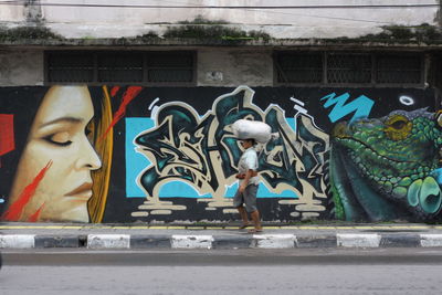 Statue against graffiti wall